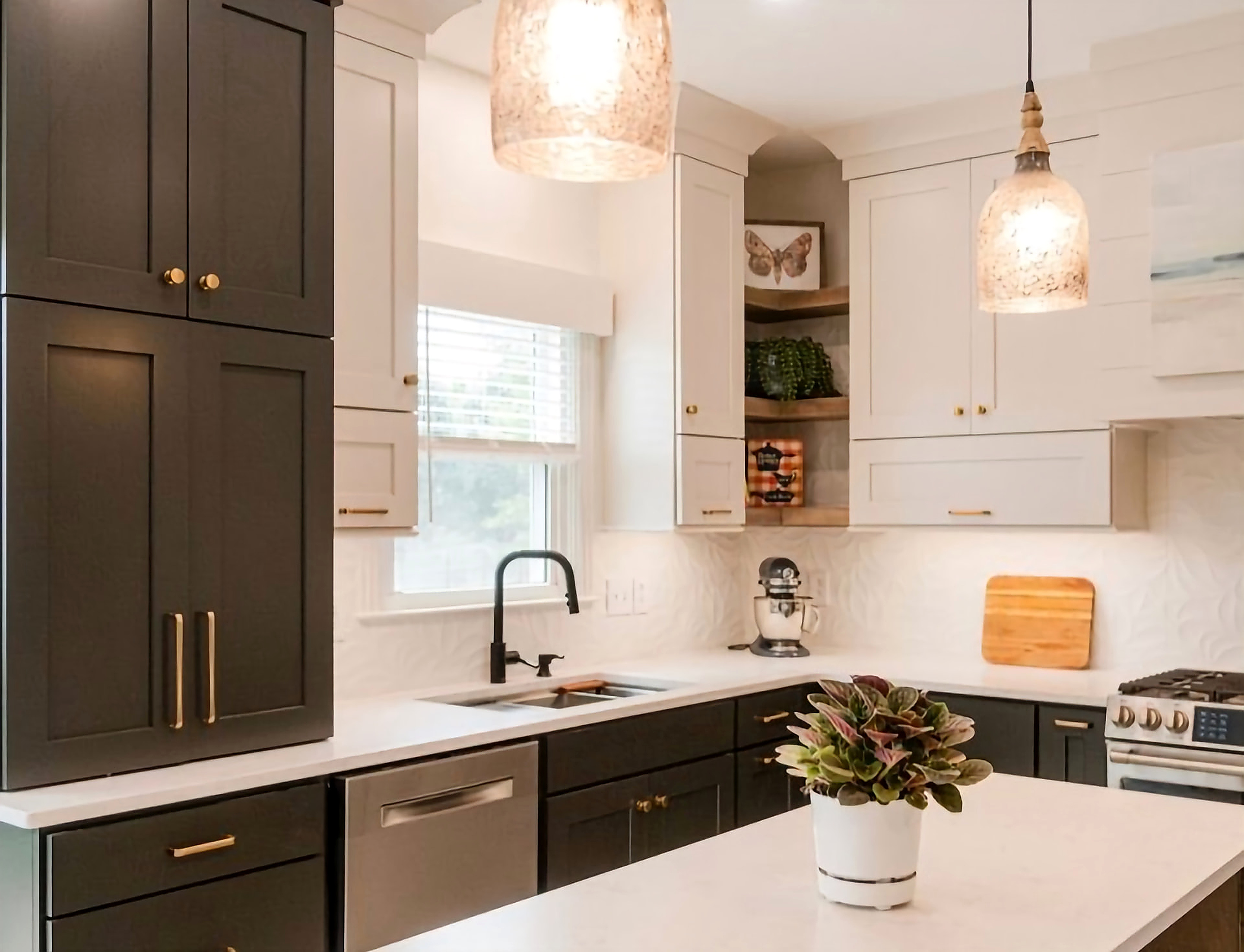 Two-tone kitchen with dark pantry cabinetry and brass hardware